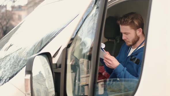 Delivery Driver Checking the Paperwork in His Van