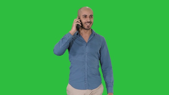 Young arab man walking and talking on the phone and smile alt