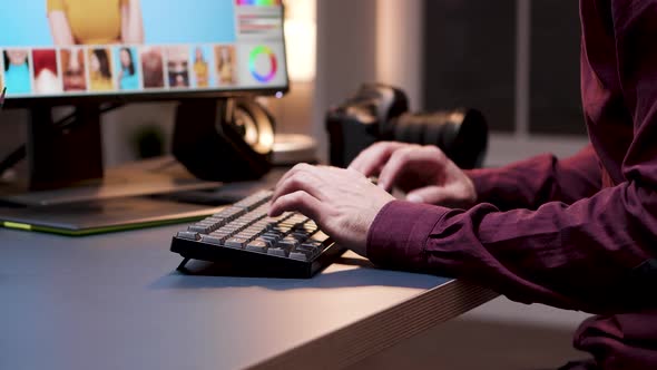 Closeup of Young Photographer Using Keyboard to Retouch Photos alt