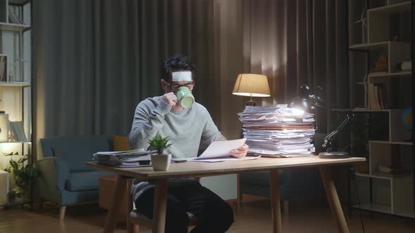 Sick Asian Man Drinking Water While Working Hard With Documents At The Home alt