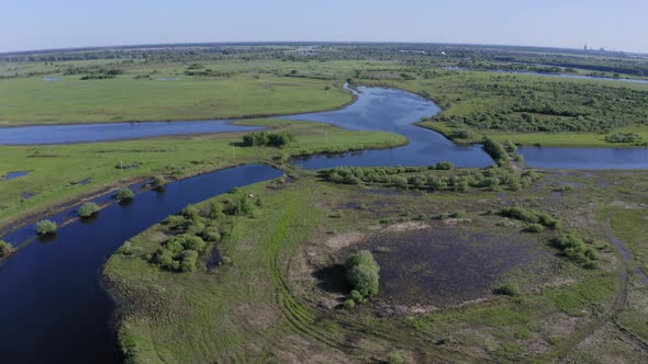 Scenic Aerial View of a River and Green Fields in a Countryside