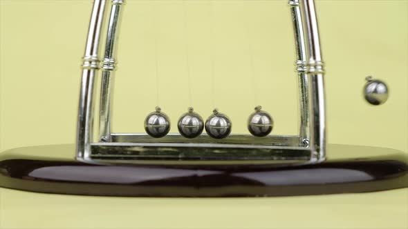 Slow motion, Newton's Cradle metal balls on green nature background