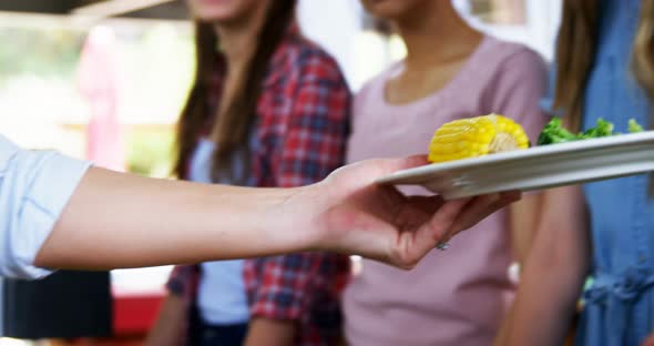 Worker serving meal to schoolkids 4k alt