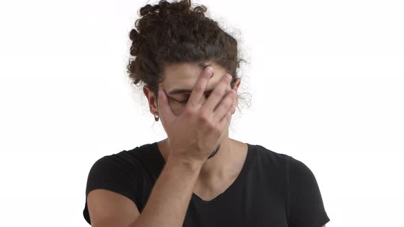 Closeup of Annoyed and Tired Hispanic Bearded Man with Curly Hairstyle Making Facepalm Then Looking alt