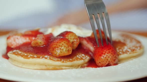 Close up pancake with strawberries, whip cream at cafe.