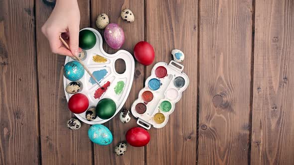Colored eggs and paint on a wooden table, Easter background. alt