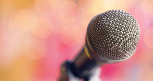 Microphone on Stage Against a Blurry Light ,Blurry Background. alt