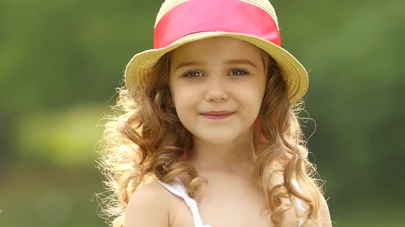 Little Girl Walks in the Park Looking Into the Distance and Dreams. Slow Motion alt