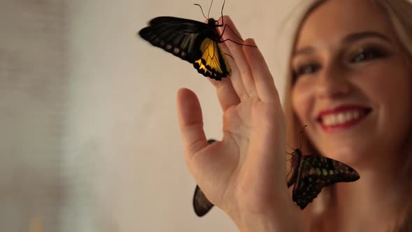 Young Charming Woman Smiling with Butterflies on her Hand