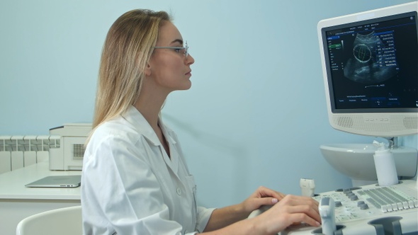Young blonde female doctor viewing an ultrasound result