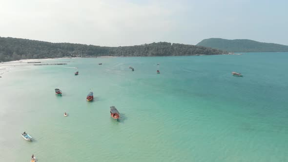 Cambodian wooden rural fishing boats resting on the turquoise exotic Saracen Bay in Koh Rong Sanloem alt