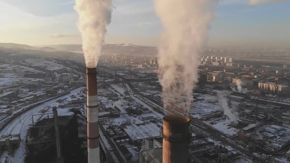 Aerial view of smoke rising from the chimney of a coal boiler. Slow motion, top view