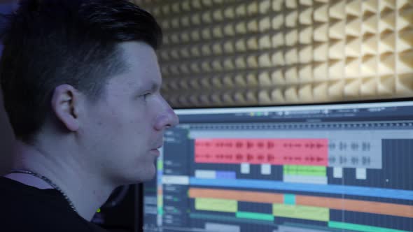 Sound engineer at music computer monitor and mixing console alt