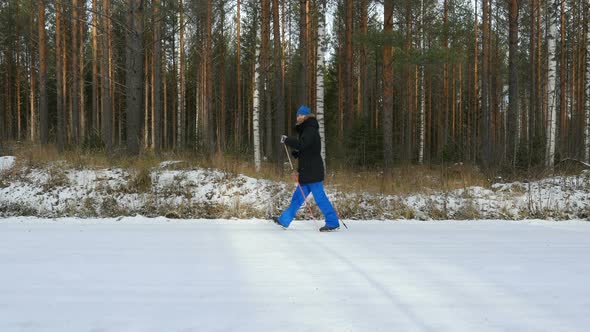 Young Man Does Sport, Fitness, Nordic Walking And Exercising Outdoors, Winter Forest, Countryside. alt