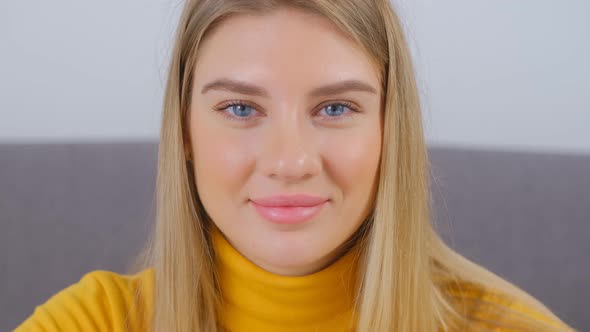 Video portrait of attractive young blonde woman with blue eyes posing with cheerful smile in 4k alt