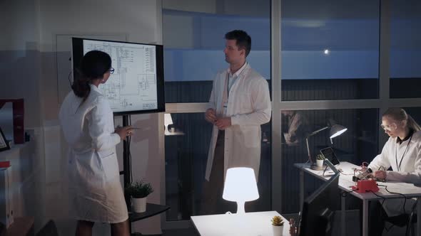 Chief Engineer Explaining Details of Investigation To His Colleague in Laboratory alt