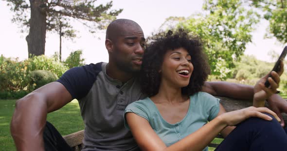 Happy mixed race couple enjoying in the garden during a sunny day alt