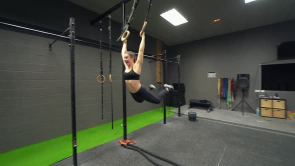 Athletes practicing on gymnastic rings at fitness centre alt