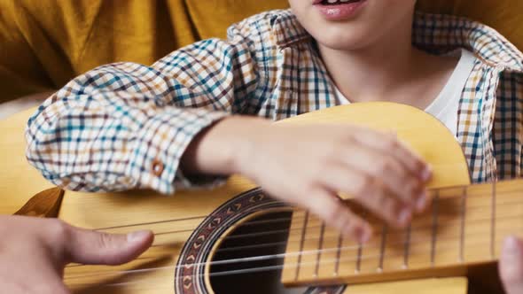 Hugging father and son playing guitar