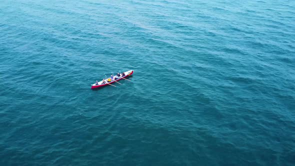 A solo rowing boat out at sea alone, on a warm sunny day off the coast of the uk, filmed with a Dji alt