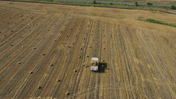 Men Load Baled Straw In A Truck alt