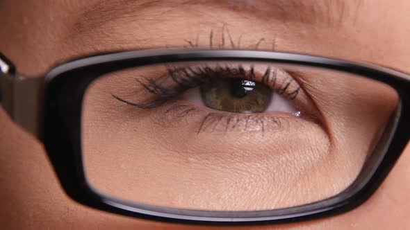 Extreme closeup of young woman's eye with glasses