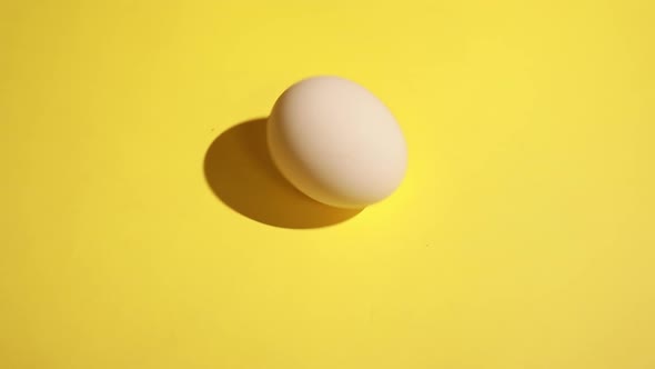 On a yellow background, four white chicken eggs