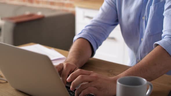 Tilt up video of man using mobile phone and laptop. Shot with RED helium camera in 8K. alt