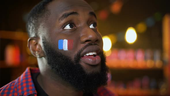 Very Emotional Black Fan With French Flag Painted on Cheek Cheering for Team alt