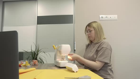 Young Blonde Dressmaker Sews Clothes