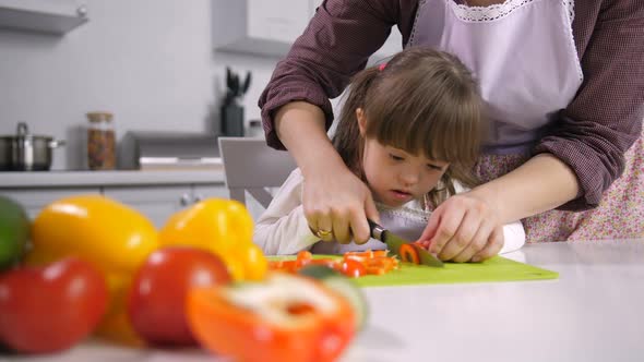 Child with Special Needs Cutting Pepper on Board alt
