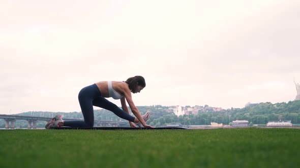 the Girl Is Engaged in Fitness on the Background of the City alt