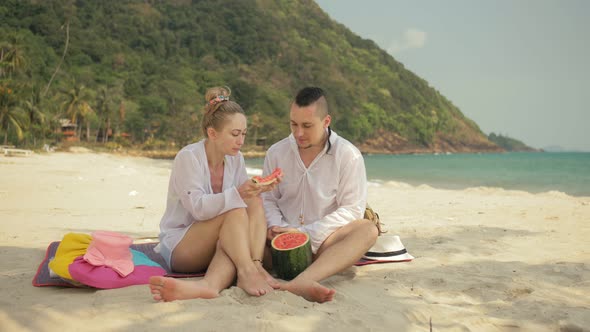 The Cheerful Love Couple Holding and Eating Slices of Watermelon on Tropical Sand Beach Sea alt