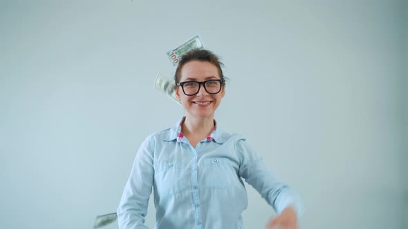 Happy Woman with Glasses Making Money Rain From Dollar Bills alt