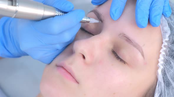 Cosmetologist Making Eyebrows Microblading Procedure in Beauty Salon for Girl