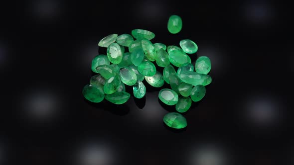 Natural Green Emerald on the Turning Table on the Black Background alt