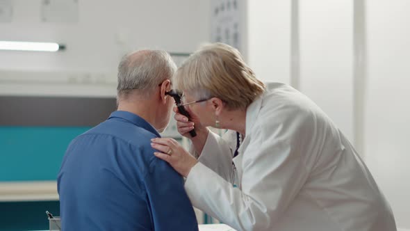 Otolaryngology Specialist Using Otoscope to Examine Ear Infection alt