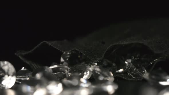 Close up of crystals fall out from a black sac on a table