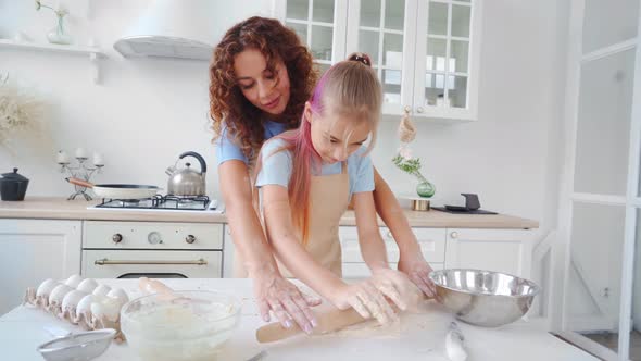 Mother and Her Teen Daughter Preparing Dough for Pizza or Cookies Together in Kitchen