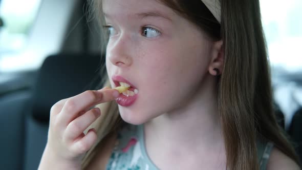 Little Girl Eating Fries in the Car Fast Food
