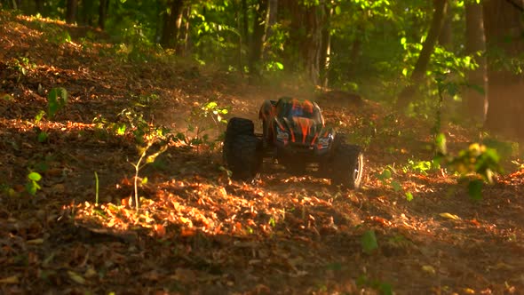 Monster Truck Rc Car Rides Over Dried Autumn Leaves. alt