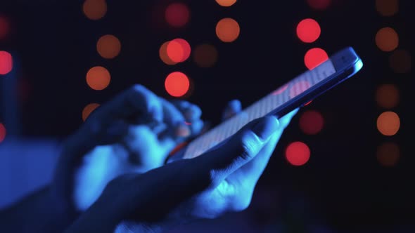 Phone in hands on bokeh background