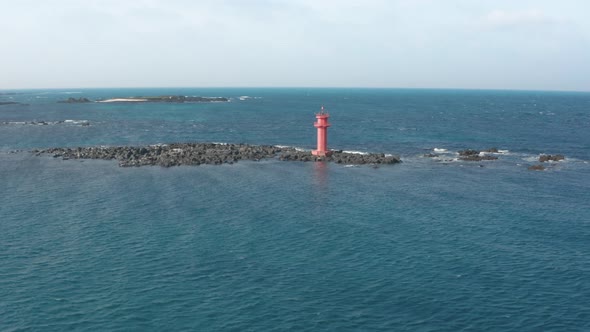 Aerial view. A lighthouse standing in the middle of the sea like an island. Dron alt