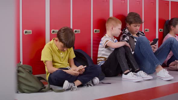 Tracking video of group of children using smartphone at school. Shot with RED helium camera in 8K. alt