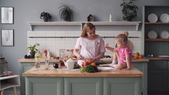 Beautiful Mother Cooking Dinner on Kitchen with Little Kid