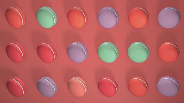 Multicolored macaron pastries on light red paper background