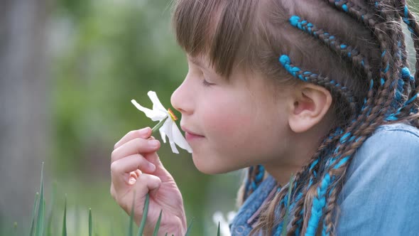 Happy Child Girl Playing in Summer Garden Enjoying Sweet Scent of White Narcissus Flowers on Sunny alt
