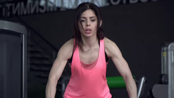 Young Attractive Woman Goes in for Sports and Trains with Ropes in the Gym alt
