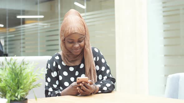 Muslim Girl in Hijab Uses Smartphone for Online Shopping alt