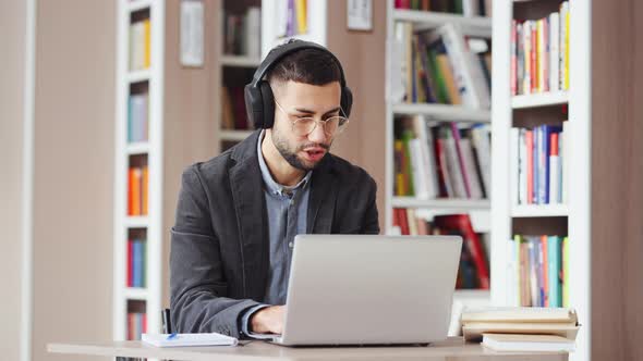 Man Working on Laptop and Listening to Music alt